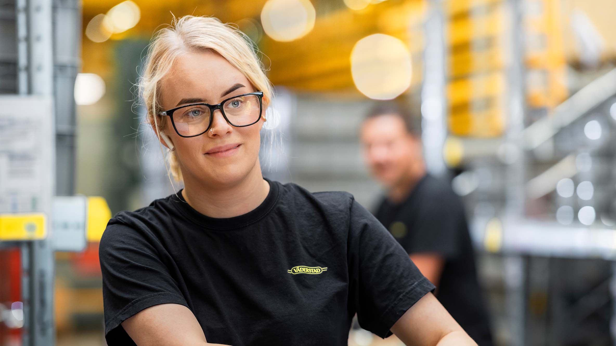 Girl working in production in a Väderstad shirt.