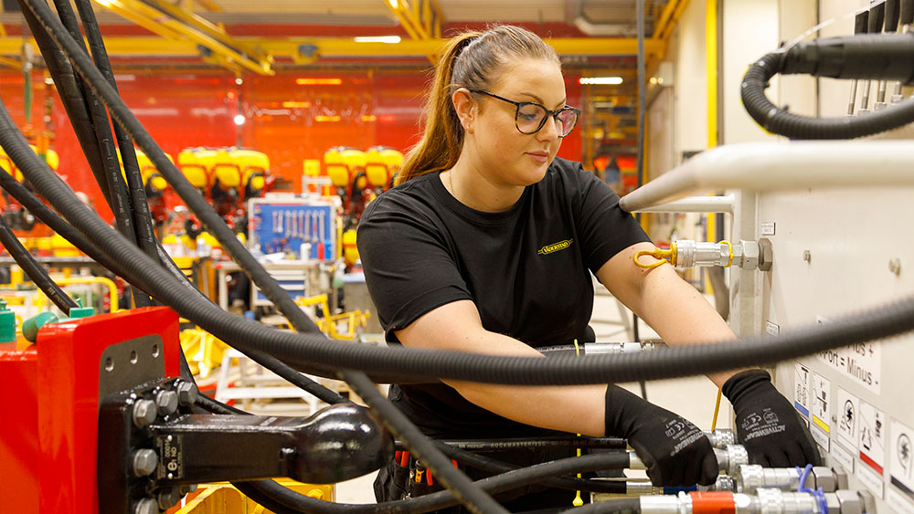 Woman working in a factory with agriculture machines