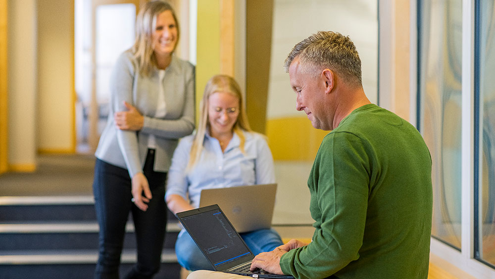 Smiling people working on their laptops