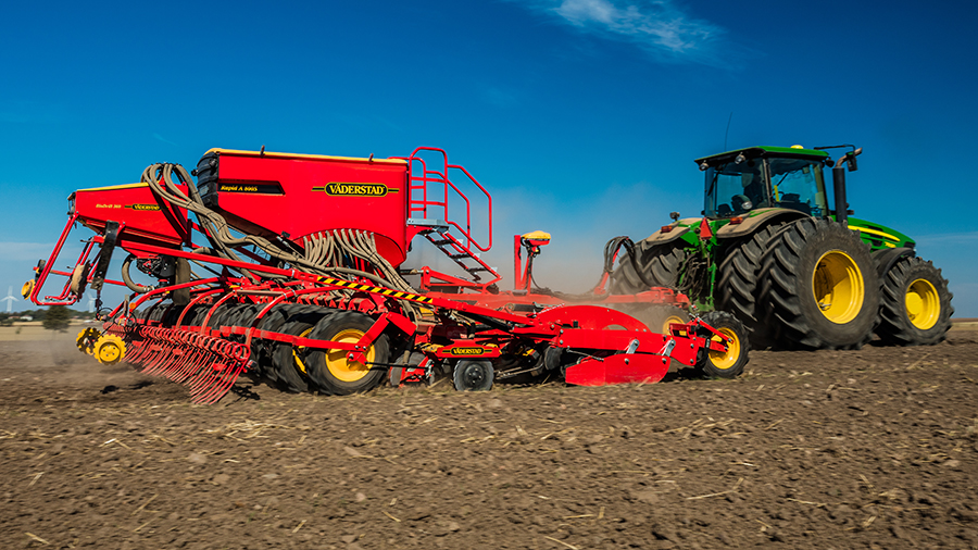 A red and yellow Väderstad Rapid seed drill in the field